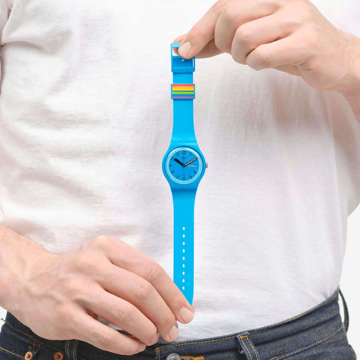 Blue quartz wristwatch on wrist with rainbow stripe detail at the top of the strap.