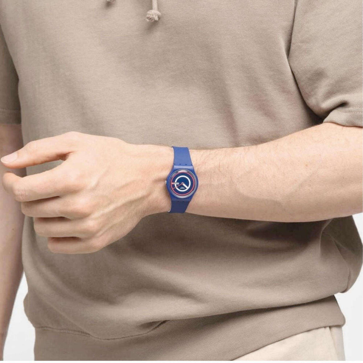Blue silicone watch on wrist, round dial with red and white rings, Fri 28 date