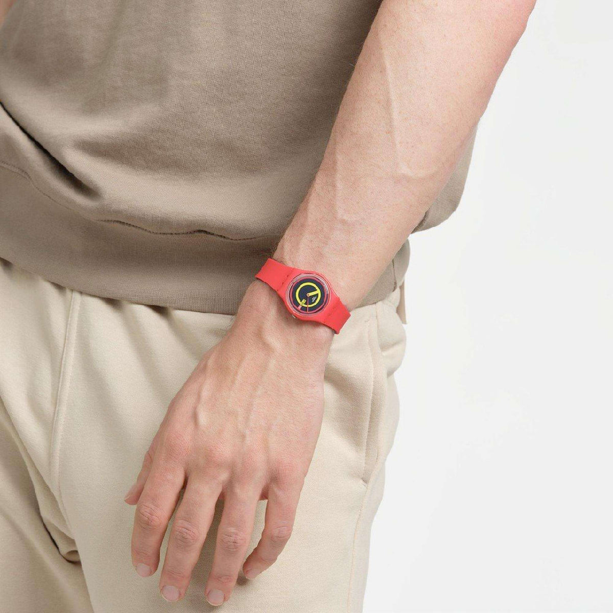 Red silicone quartz watch on hand with round multicolor dial.
