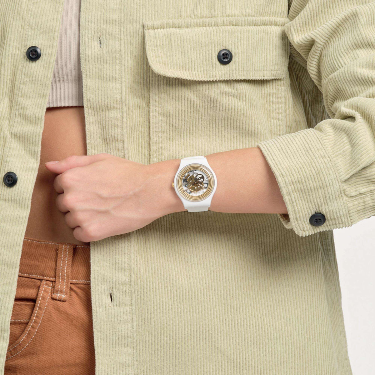 White silicone quartz watch on wrist with gold-toned skeleton dial