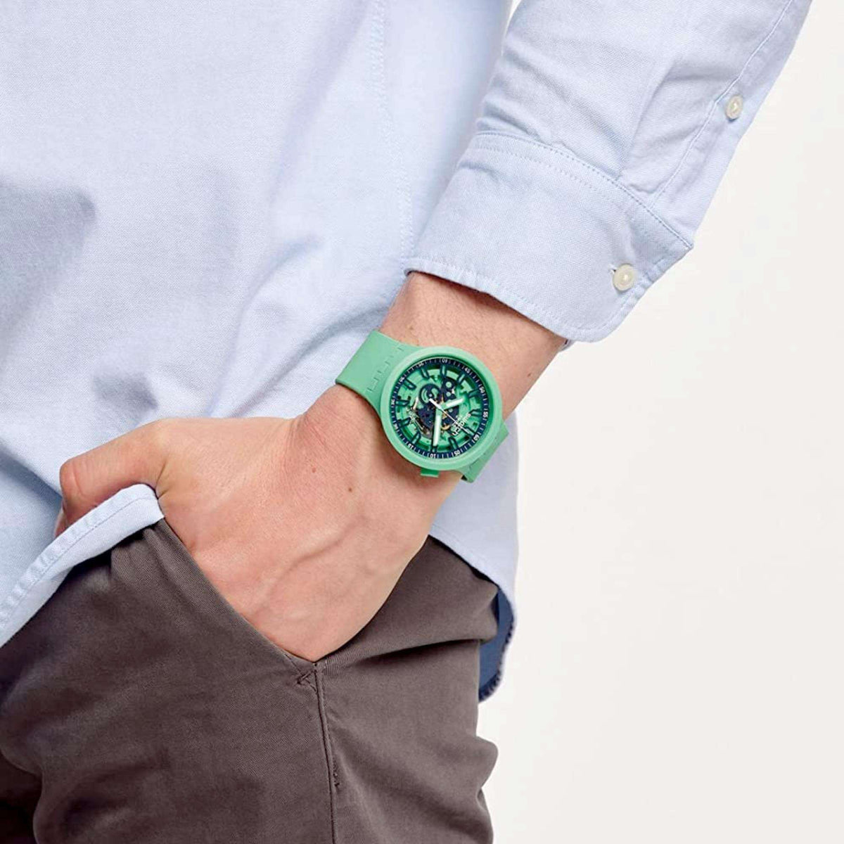 Swatch green quartz watch on wrist, green silicone strap, detailed dial