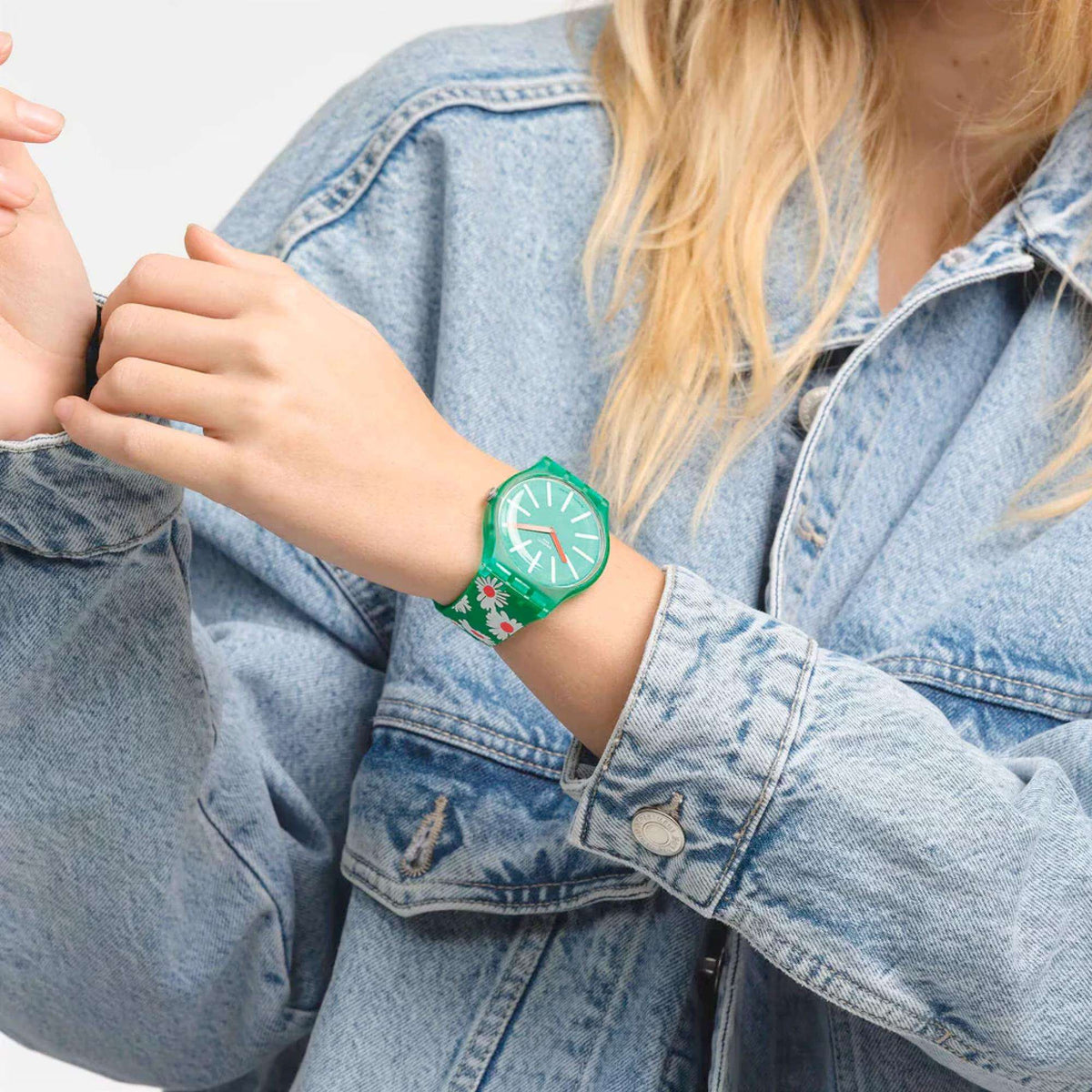 Green floral quartz watch on denim sleeve, round green dial with white markers