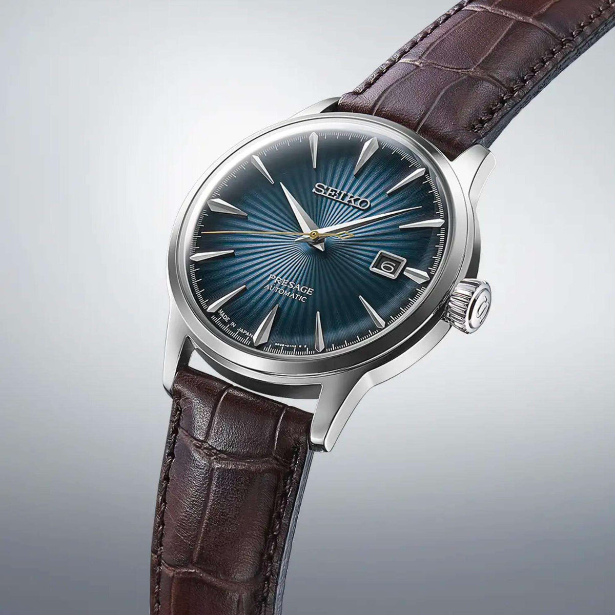 Seiko Presage Cocktail Time 'Midnight Blue Moon' SRPK15J1 angled studio view showcasing sunray blue dial and brown leather strap