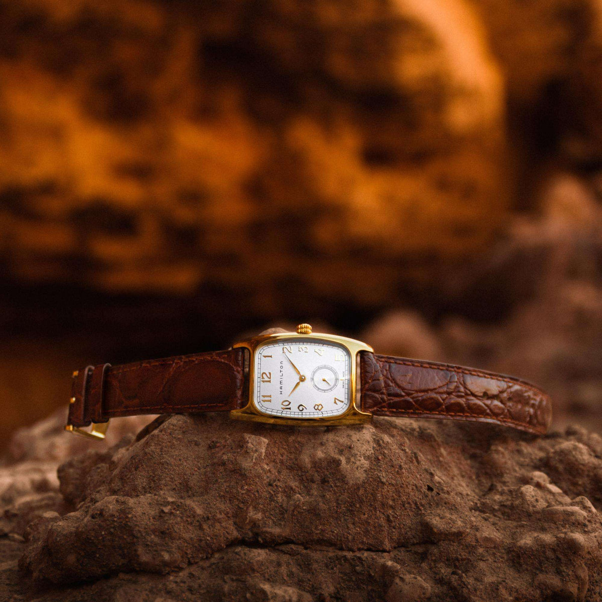Hamilton American Classic Boulton H13431553 timepiece promotional shot resting on rugged rock surface highlighting white dial