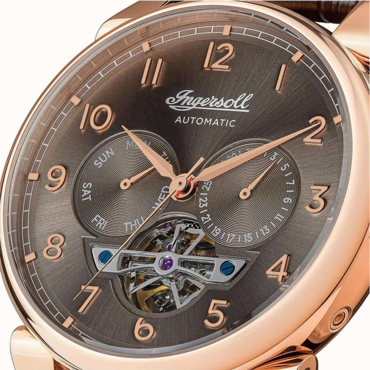 Close-up of men's automatic watch dial with dark grey sunray finish and rose-gold hour markers