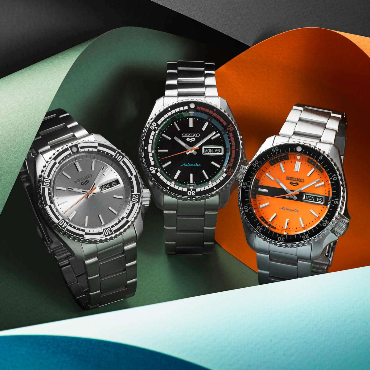 Seiko men's automatic diver watch collection of three, black, grey, and orange dials