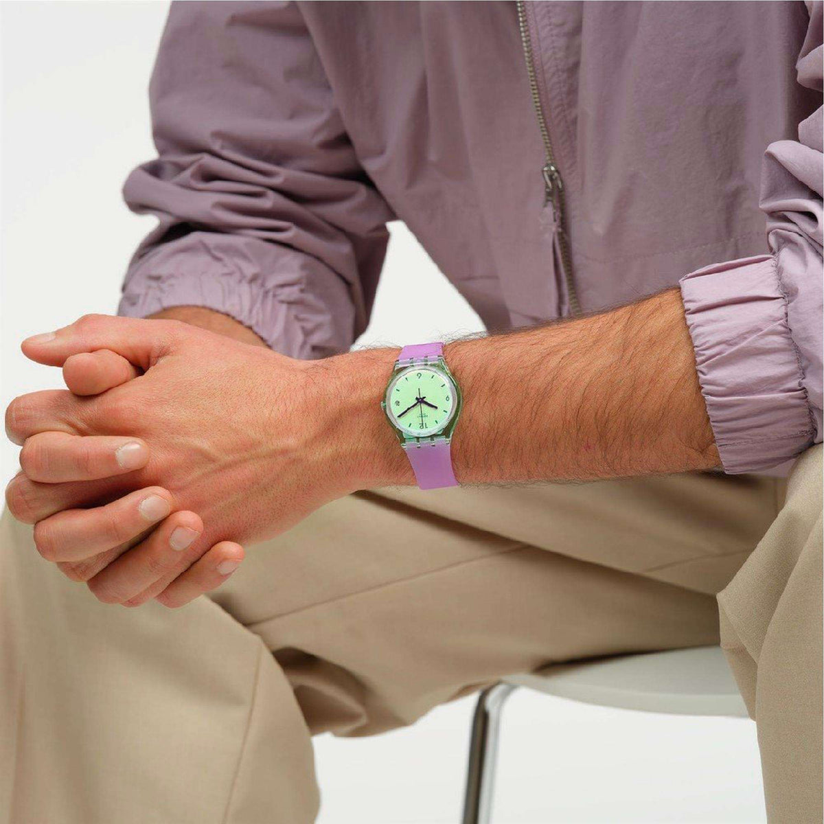 Quartz wristwatch on wrist with mint green face and purple silicone band