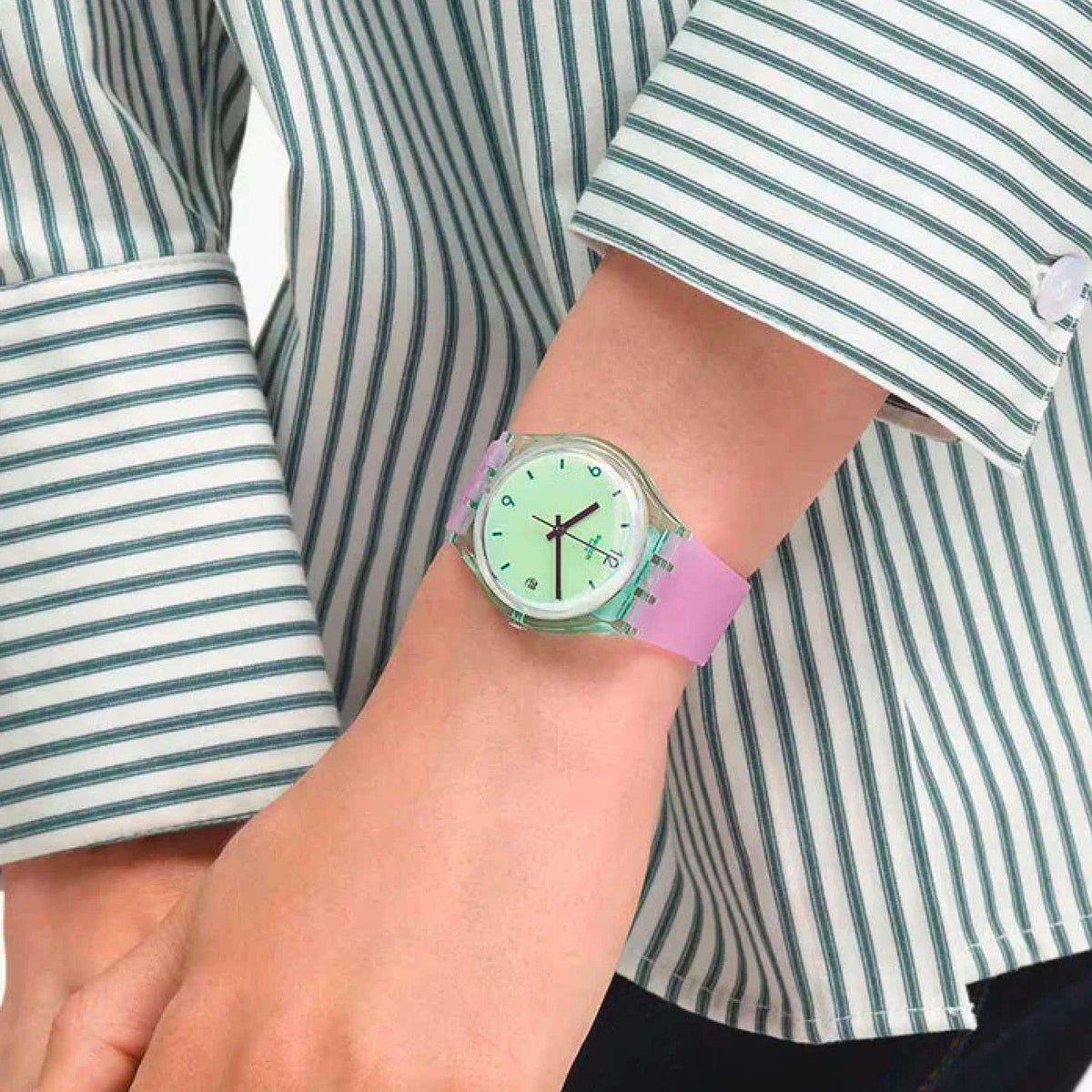 Quartz wristwatch worn with striped shirt sleeves; mint dial and purple silicone strap