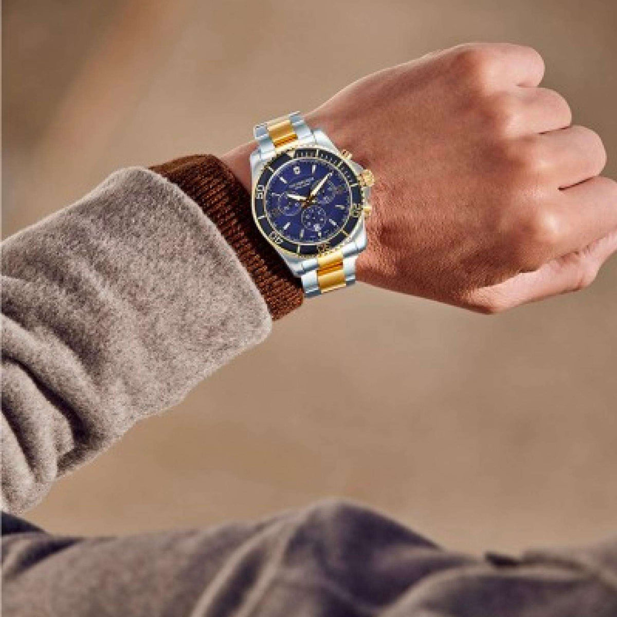 Two-tone men's quartz watch with blue dial worn on a wrist