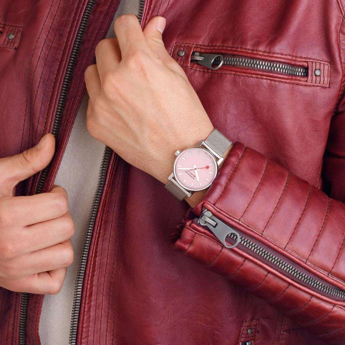 Ladies silver watch with pink dial on wrist, silver mesh steel bracelet visible