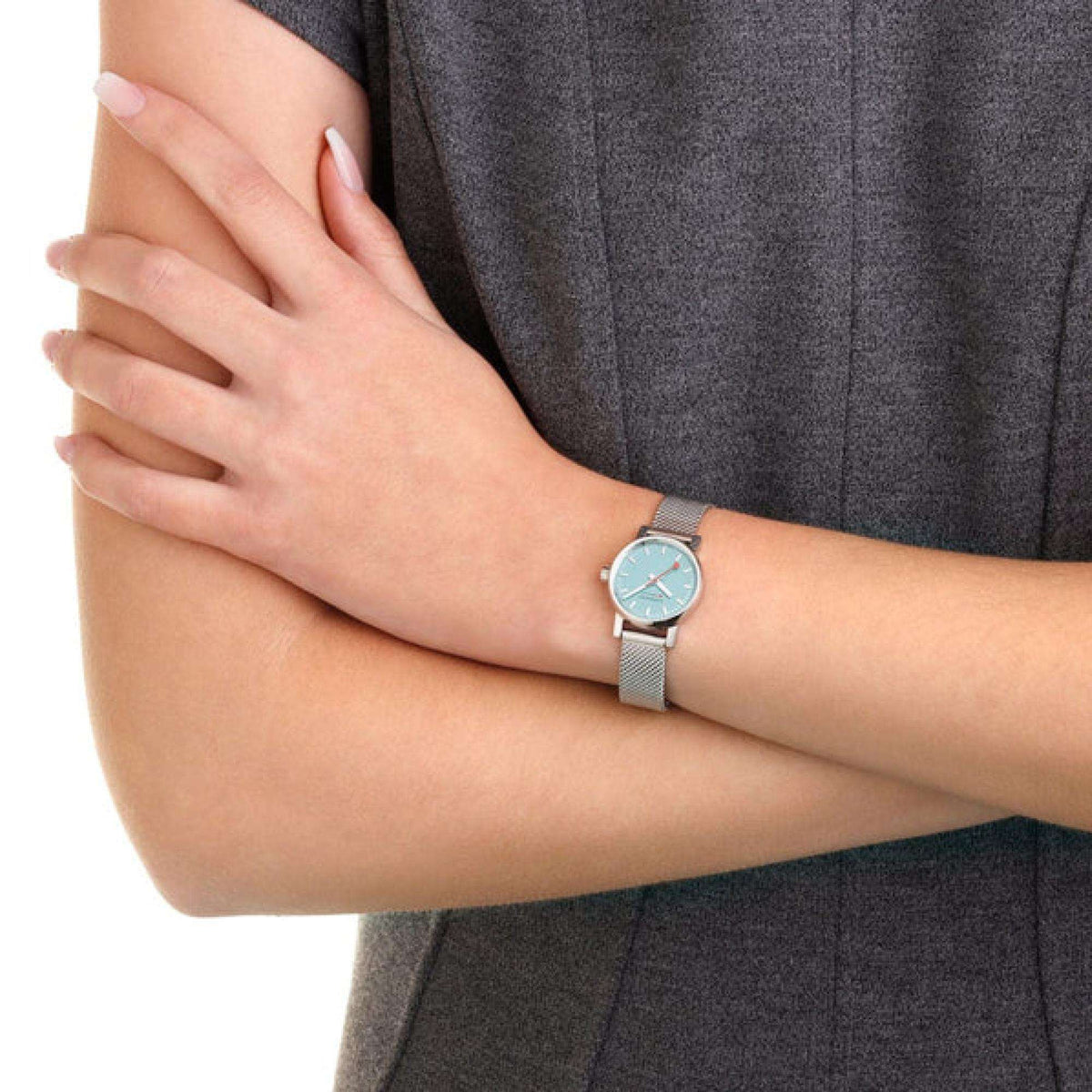 Ladies watch on wrist with light blue dial and silver mesh stainless bracelet