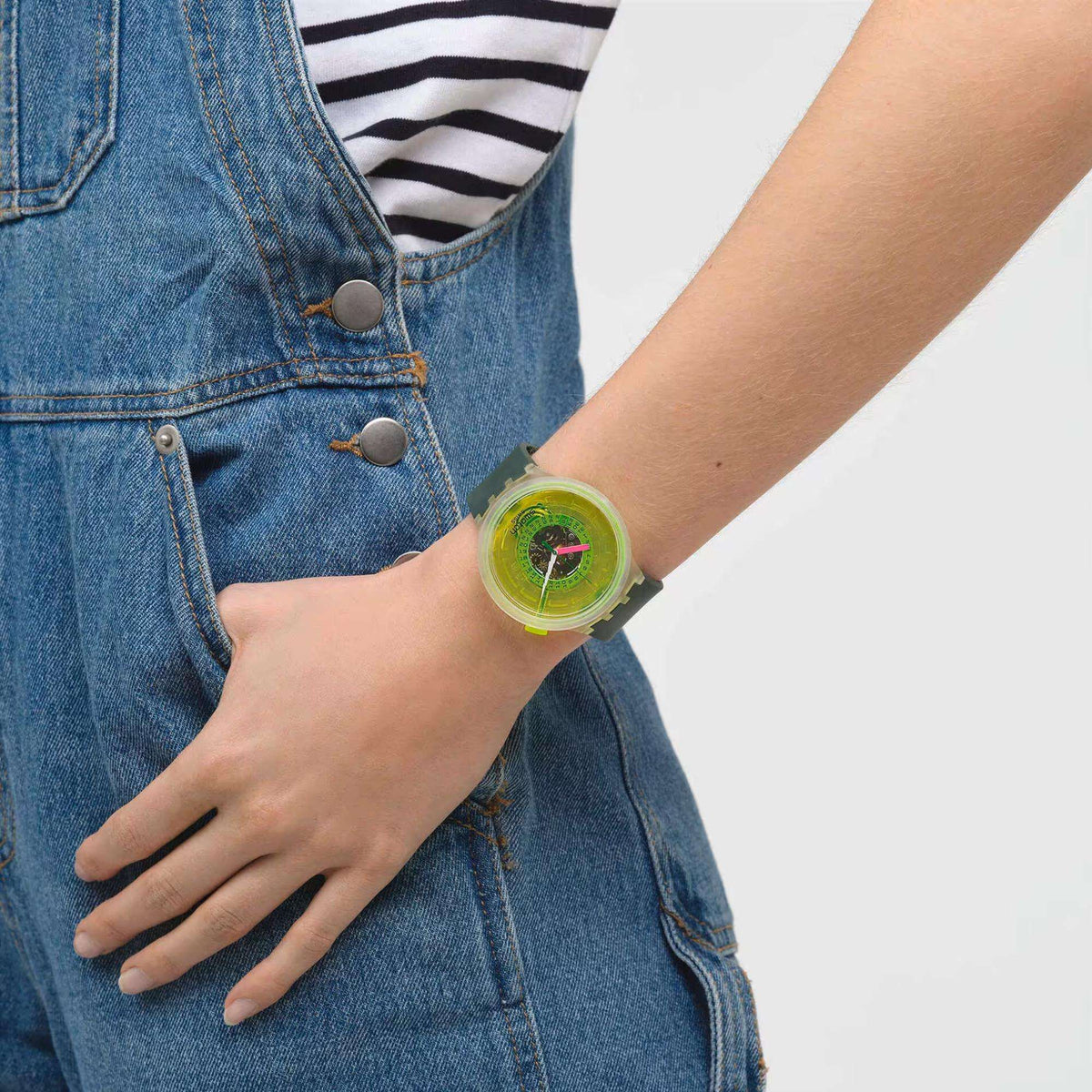 Swatch neon quartz watch on wrist with neon green dial and dark green strap