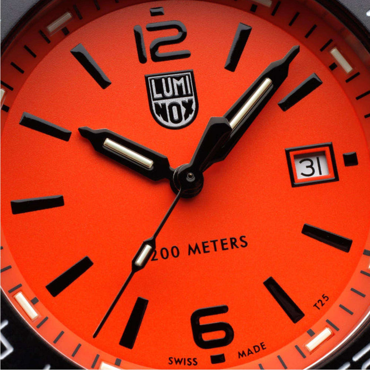 Orange dial close-up with LUMINOX logo, black hands, and date at 3 o'clock