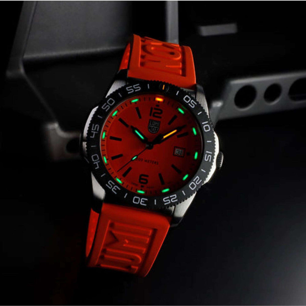 Diver watch with orange dial and green luminous markers, orange rubber strap, date window