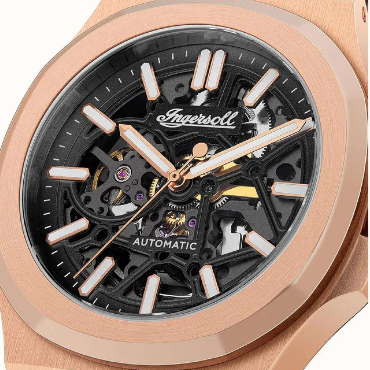 Black skeleton watch dial close-up with rose-gold hands and automatic text