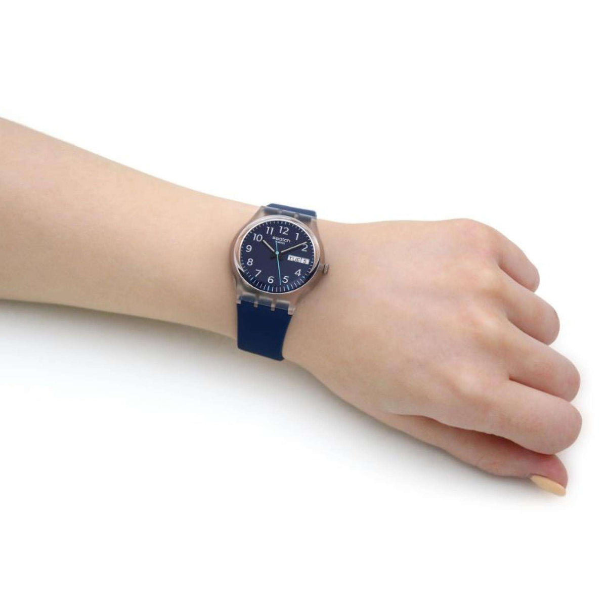 Navy blue dial watch on wrist, dark-blue strap visible with silver case