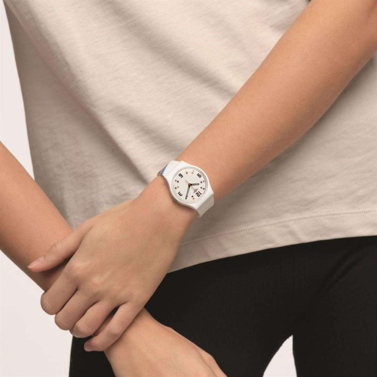 White men’s Swatch watch with colorful pixel-number dial on wrist