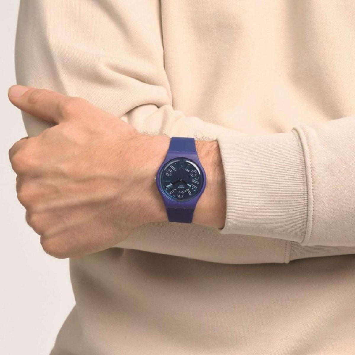 Men's Swatch wristwatch on a wrist with blue dial and purple-blue silicone strap