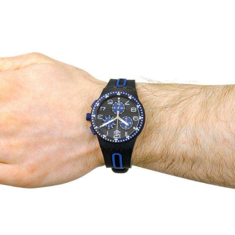Men's black dial watch with blue subdials on wrist, silicone strap