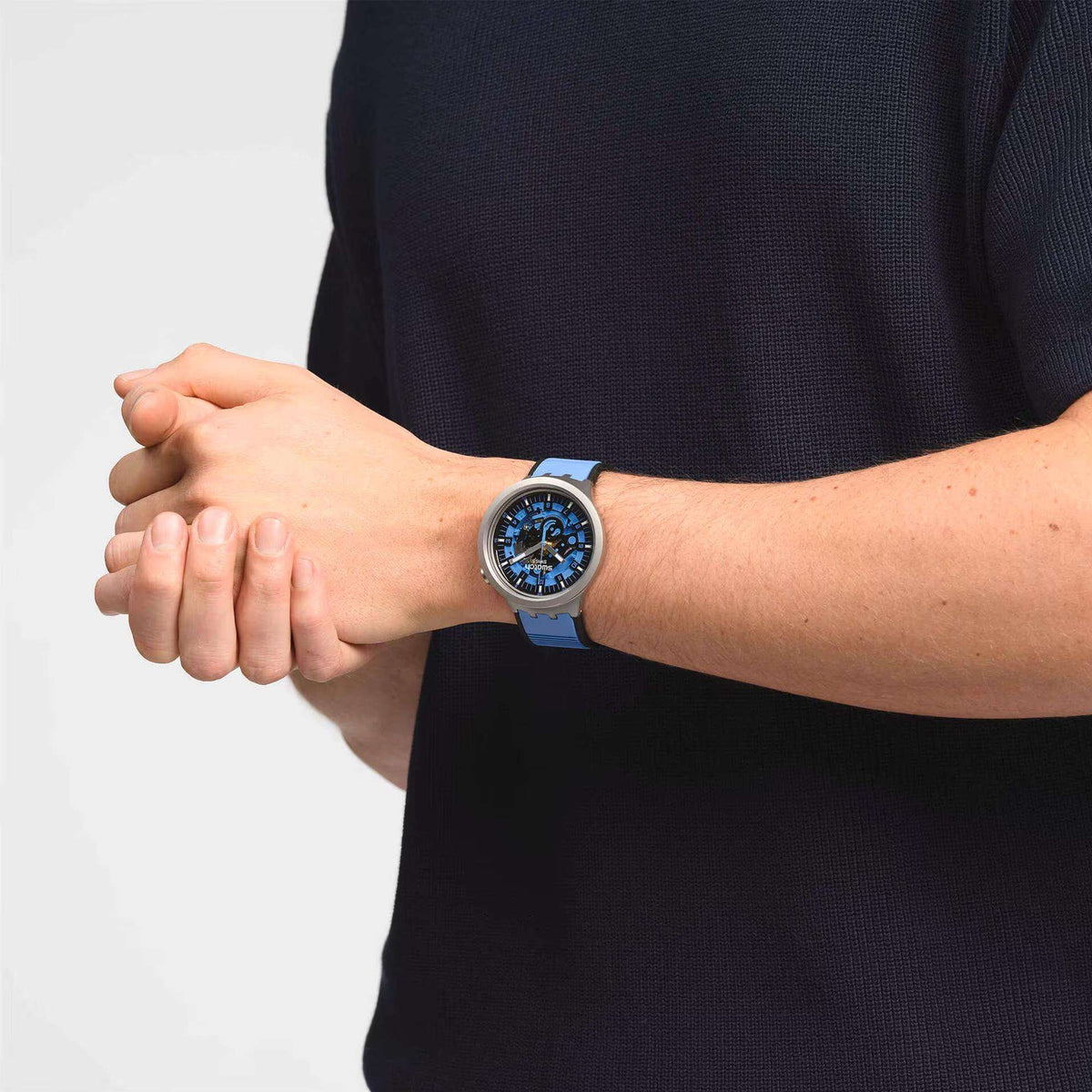 Swatch blue quartz watch on wrist with blue rubber strap and blue dial