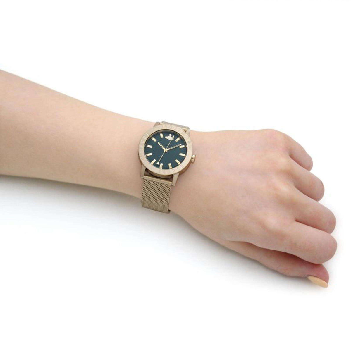 Gold-tone mesh bracelet wristwatch with green dial on a person’s hand