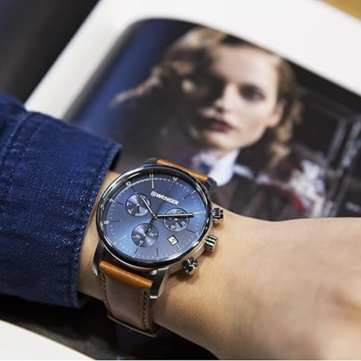 Men’s chronograph watch with blue dial and brown leather strap on wrist