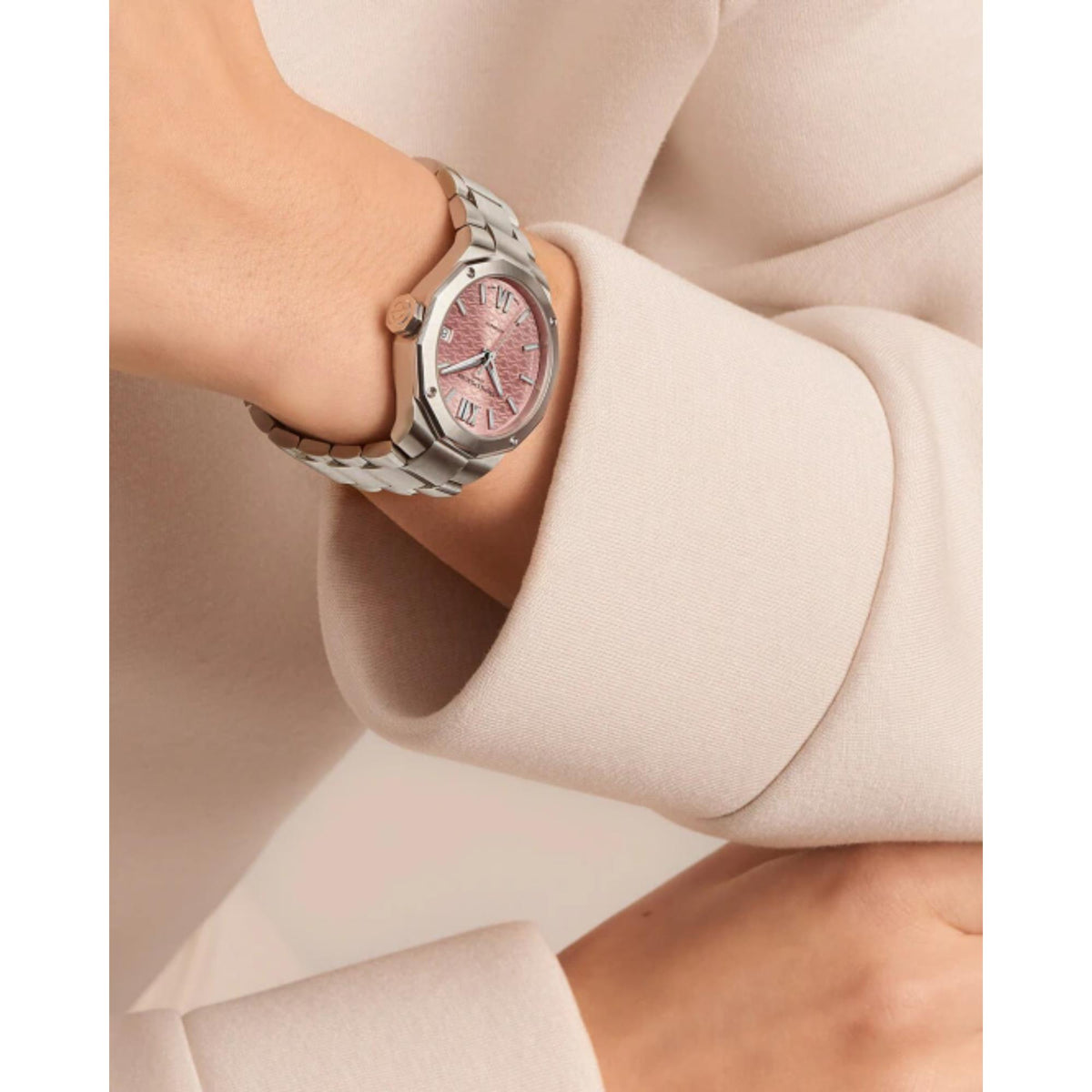 Ladies stainless steel watch on wrist with pink dial and polished metal link bracelet