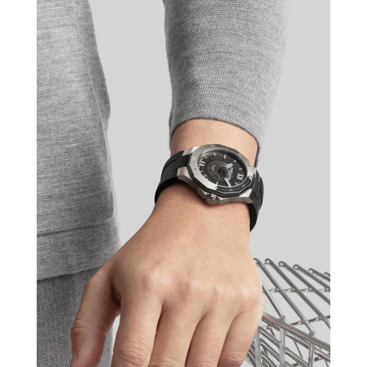 Men's stainless steel watch on wrist with black dial and metal bracelet