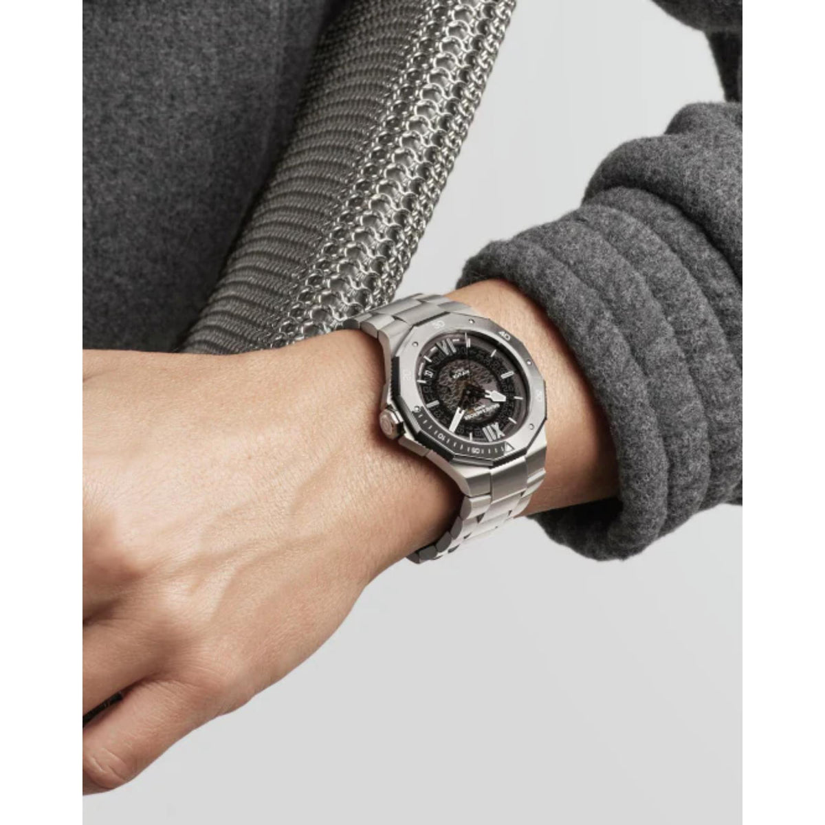 Men's stainless steel automatic watch with black dial shown on wrist in close view