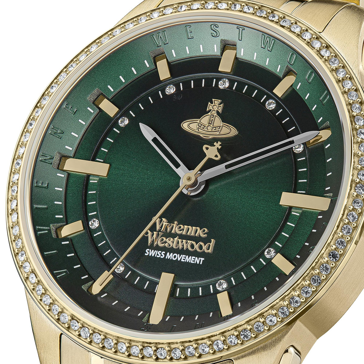 Close-up gold watch face with green dial, baton markers, and jeweled bezel