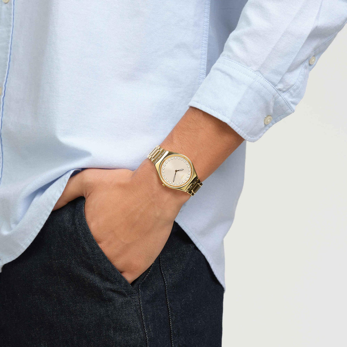 Unisex gold-tone quartz wristwatch on wrist with beige dial and gold link bracelet