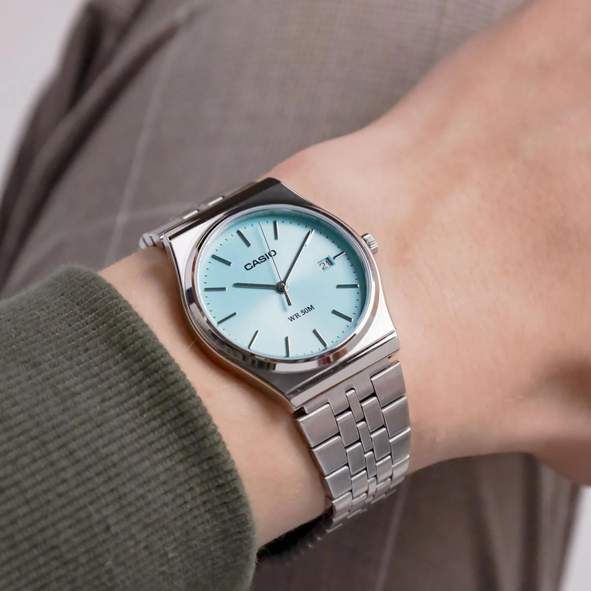 Casio quartz watch with light blue dial and stainless steel link bracelet on wrist