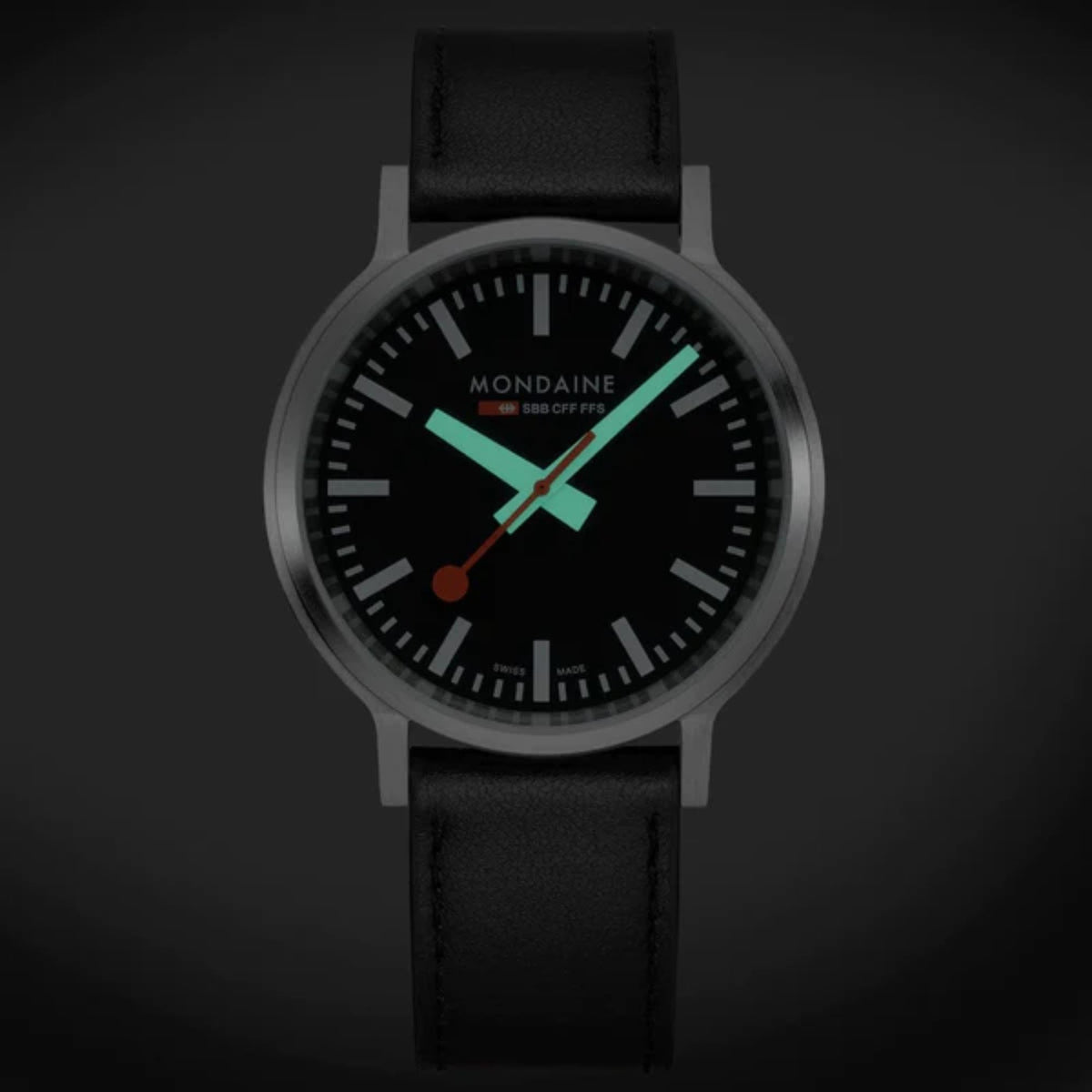 Mondaine stop2go watch with black dial, orange and green accent hands, black leather strap