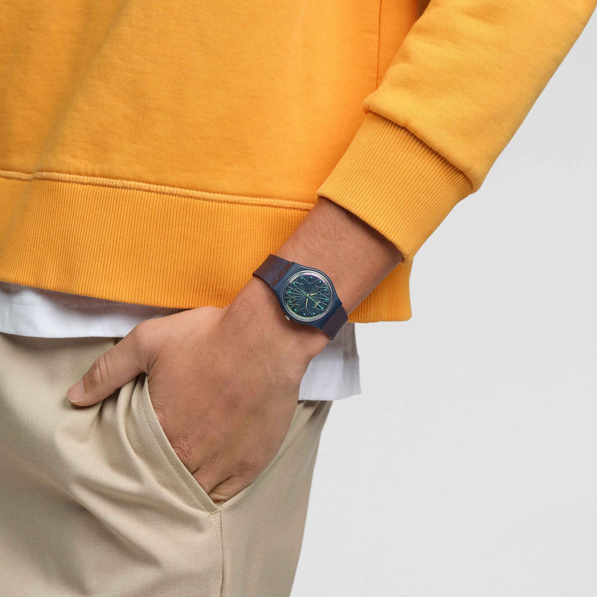 Silicone wristwatch with blue dial and yellow hands on a wrist