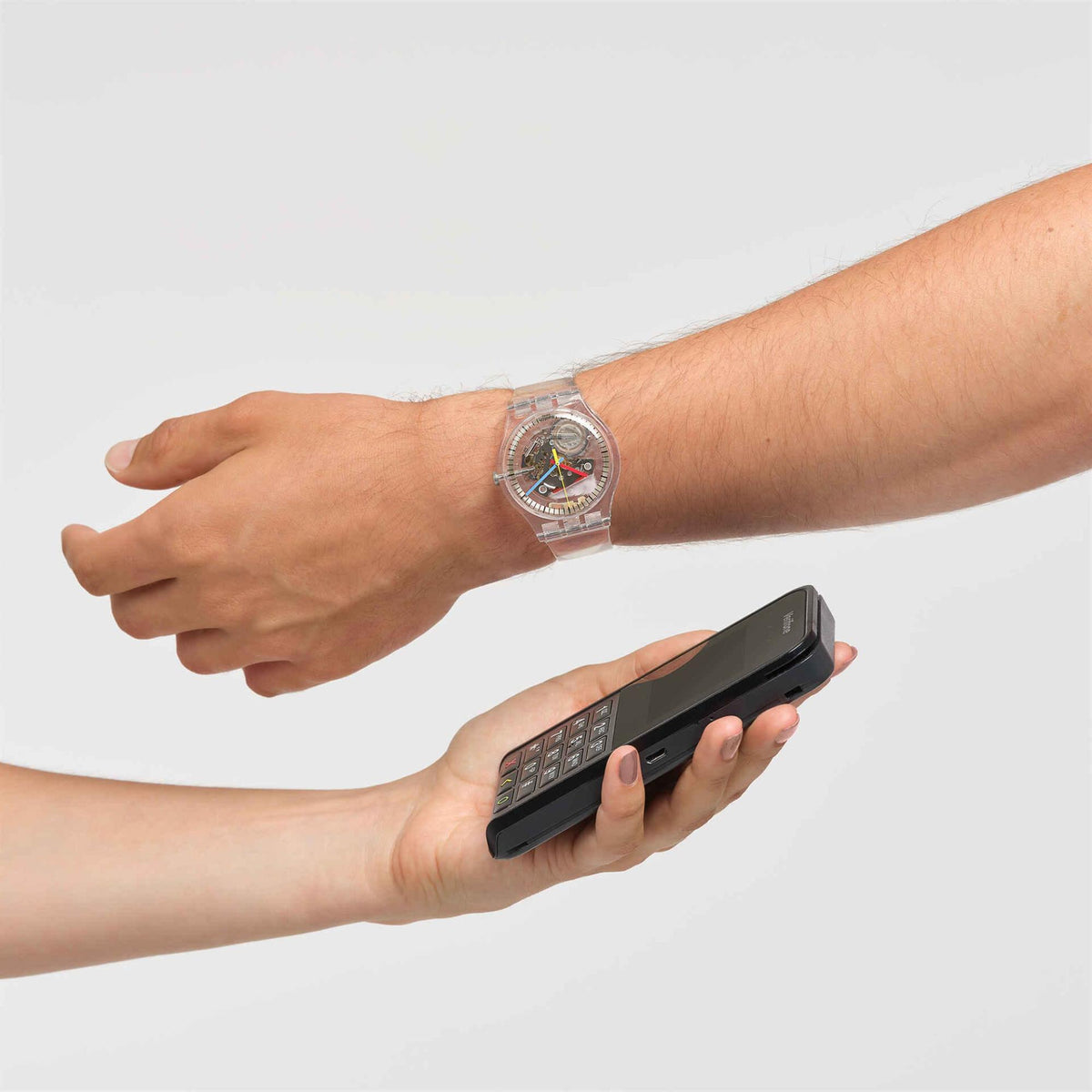 Quartz silicone watch on wrist with white strap; hand holds a smartphone