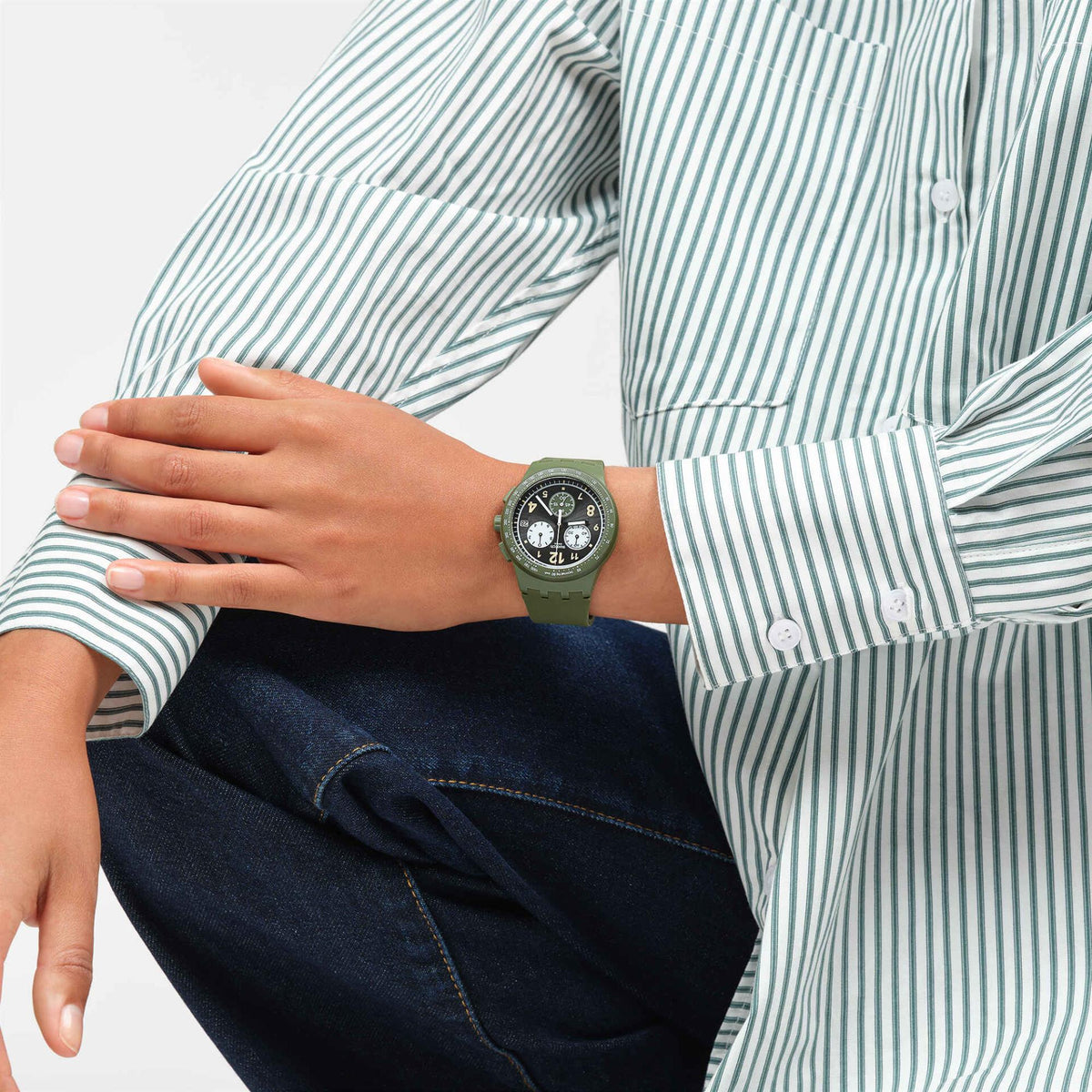 Quartz watch on wrist with olive silicone band and round dark dial
