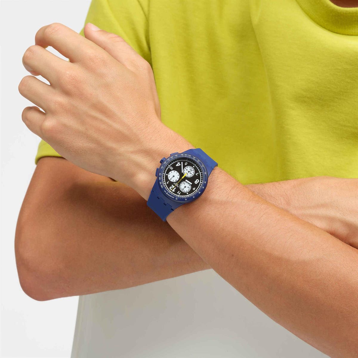 Blue silicone strap watch on wrist with black dial and white numerals