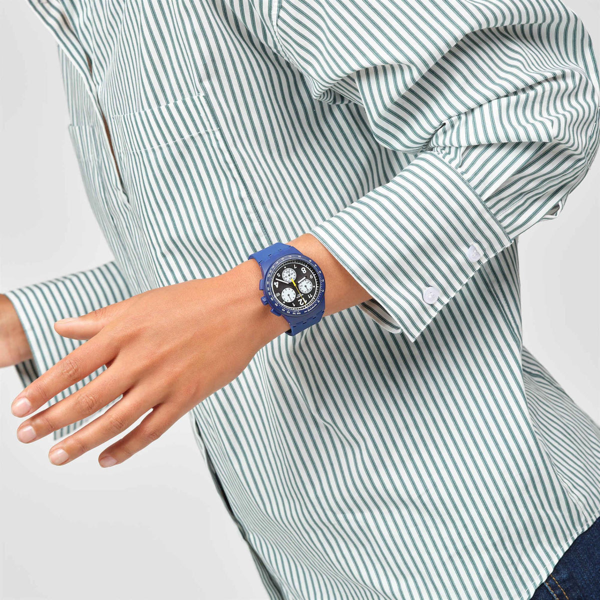 Blue silicone strap watch worn on wrist with black dial and multiple subdials