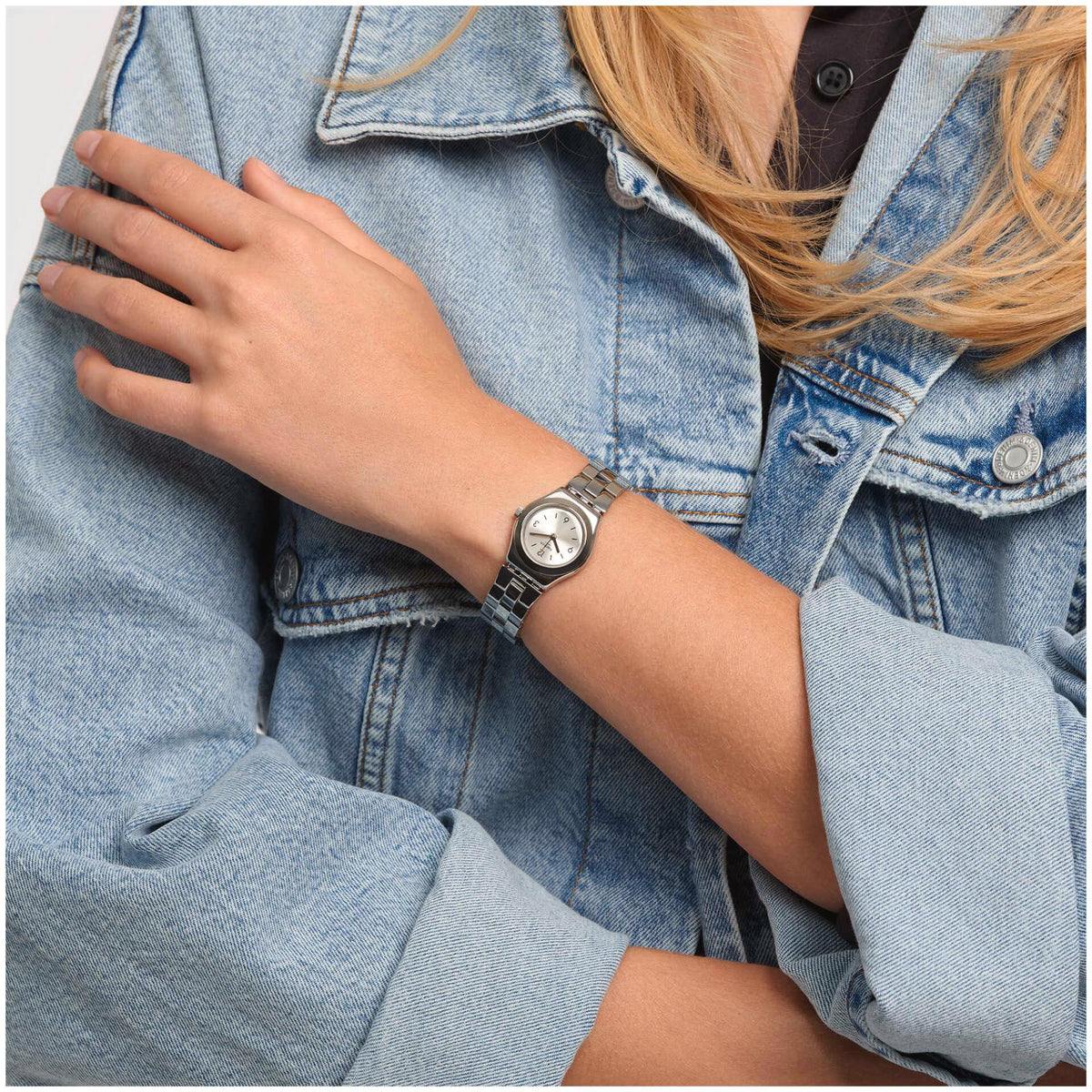 Stainless steel ladies quartz watch on wrist with silver dial and linked bracelet