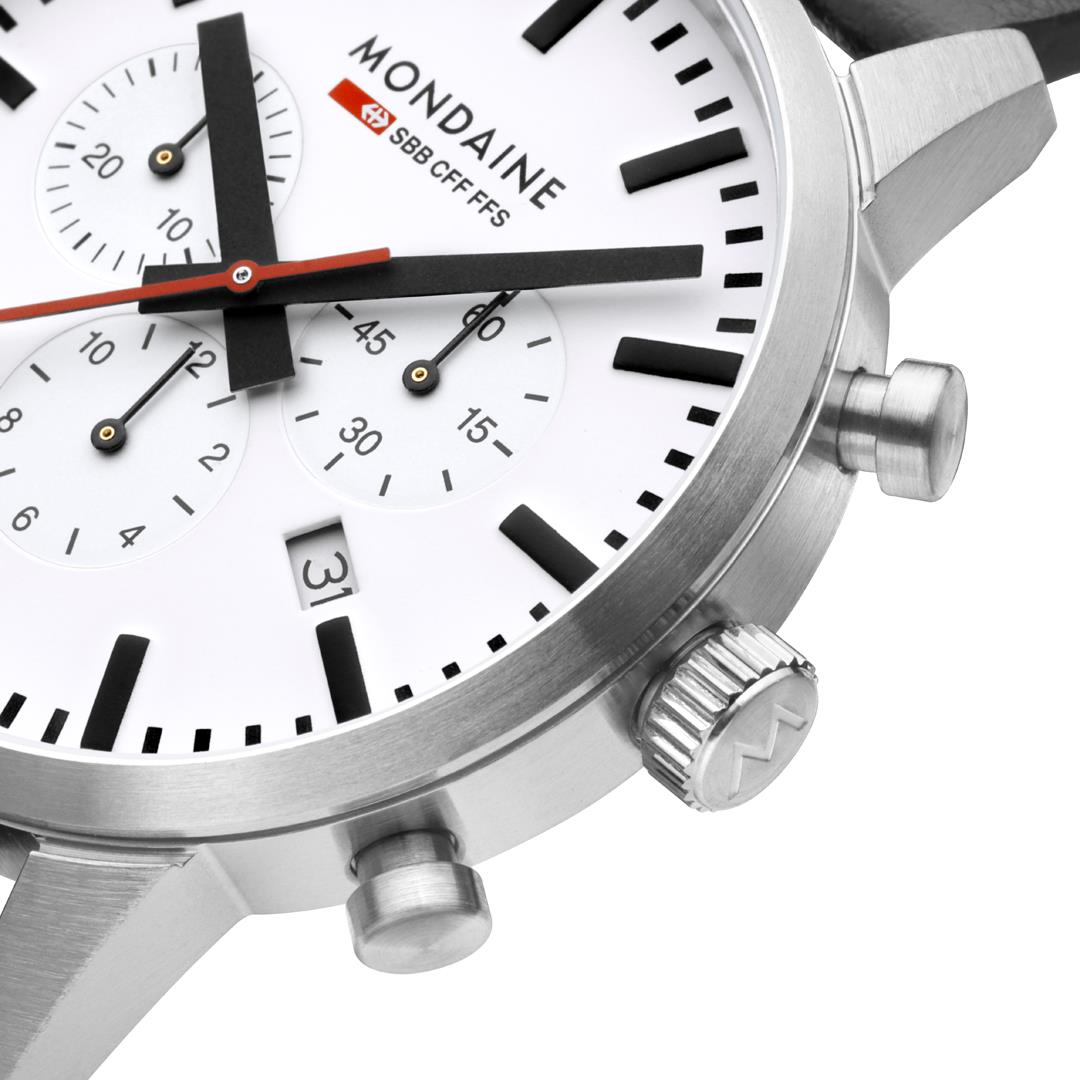 Close-up of men's watch dial: white face with black markers, red accents, chronograph subdials