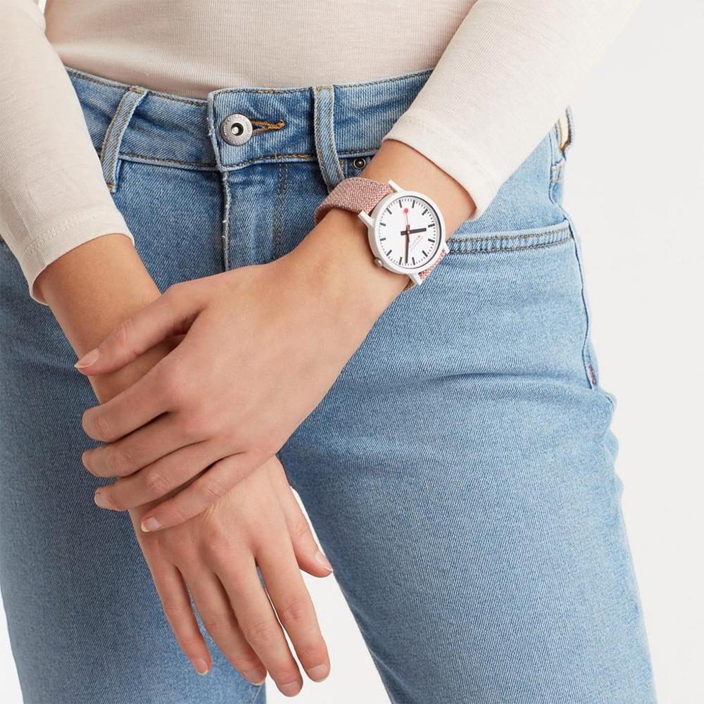 Mondaine quartz watch on wrist, white dial with red hands, textile strap