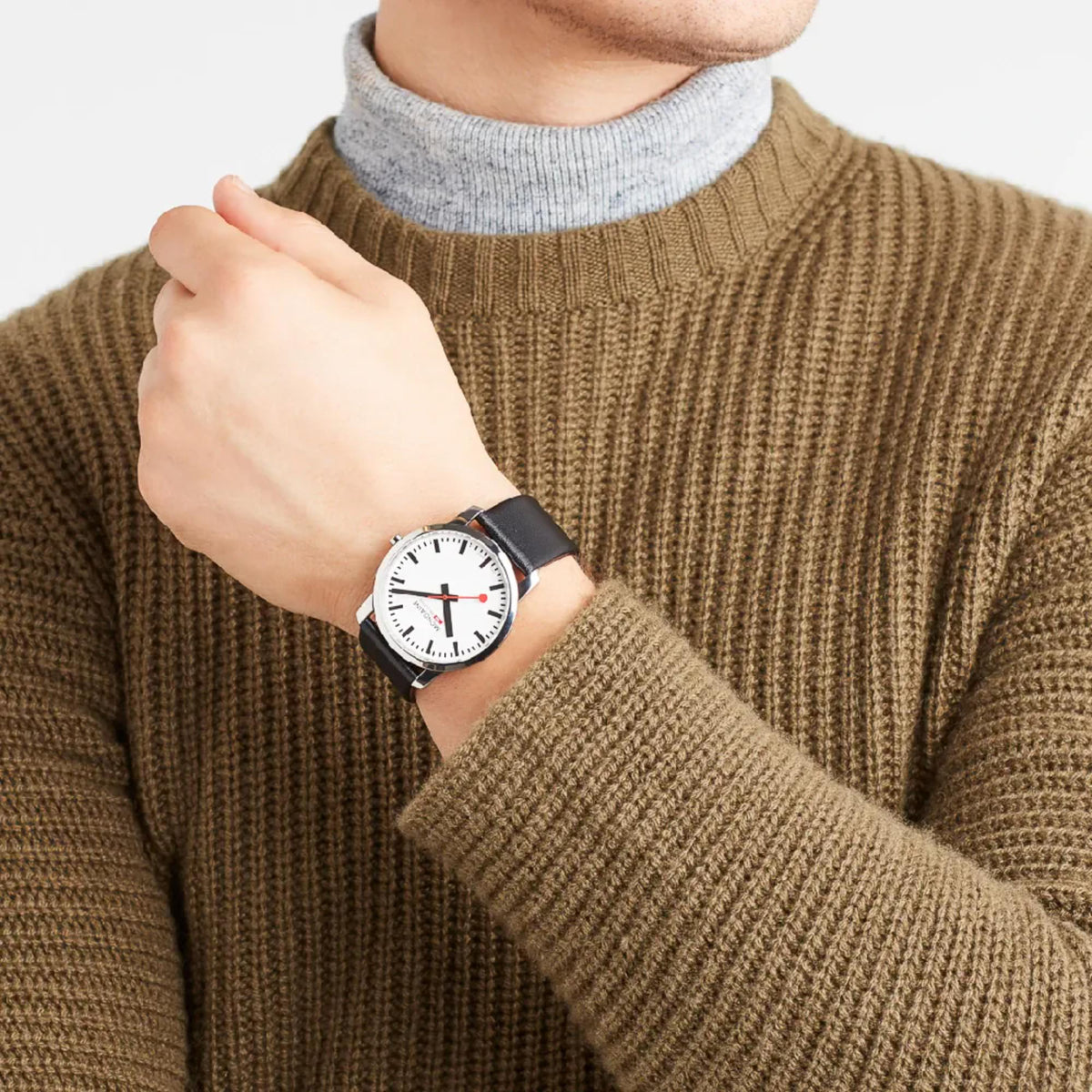 Men's watch on black leather strap with white dial, worn on wrist