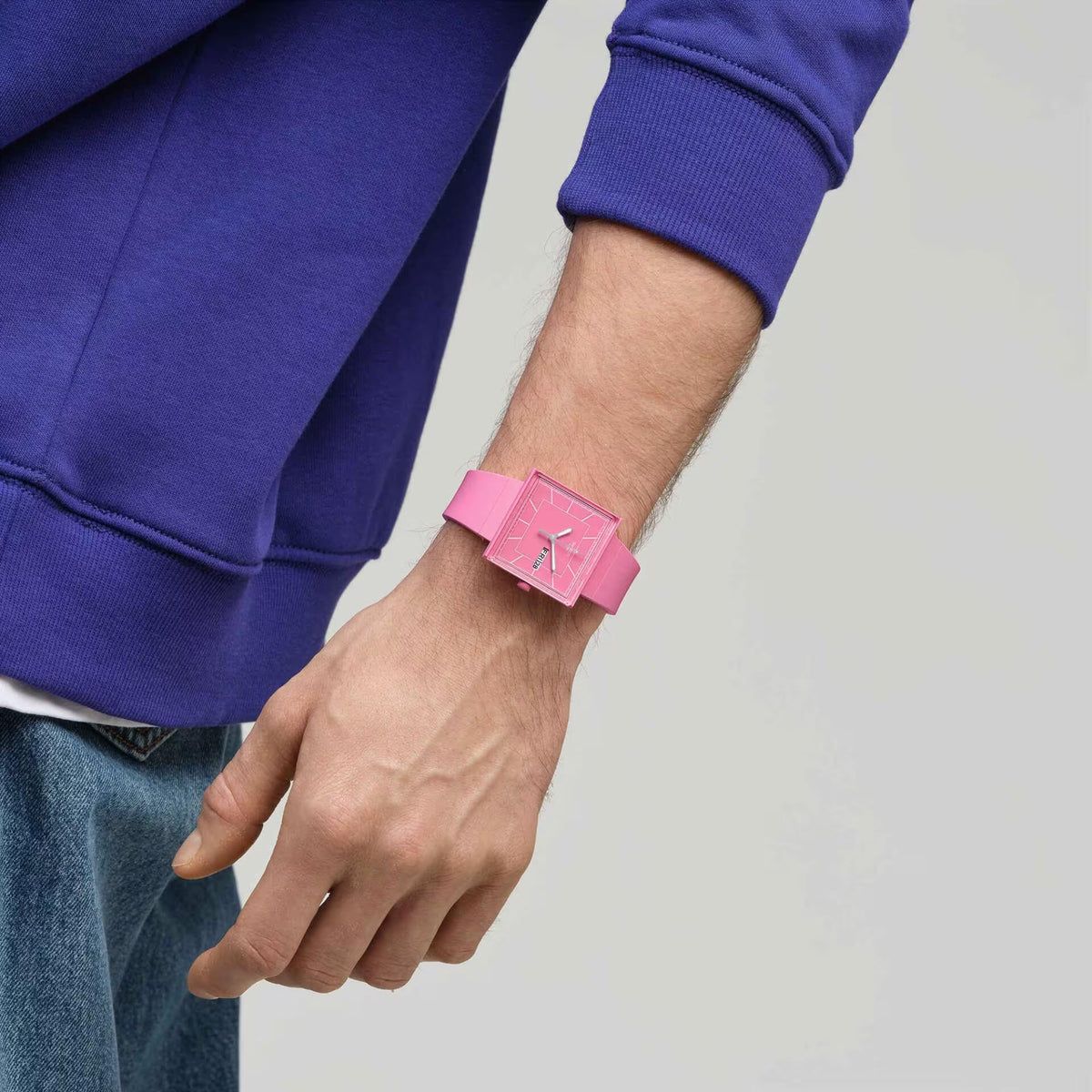 Quartz pink watch on wrist with pink silicone strap, square case and analog dial