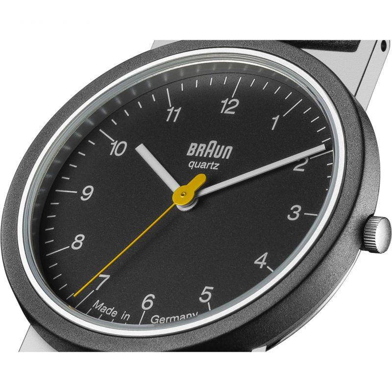 Close-up of men's black quartz watch dial with yellow hands and silver minute markers