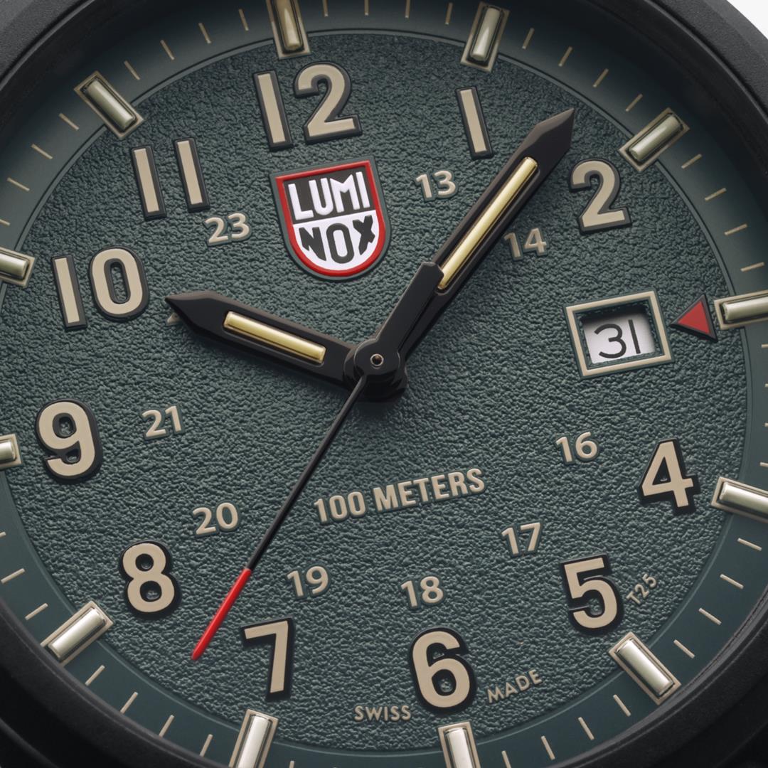 Close-up of the Luminox Atacama Field XL.1977 textured green dial showing 24-hour time scale, date window, and red-tipped second hand
