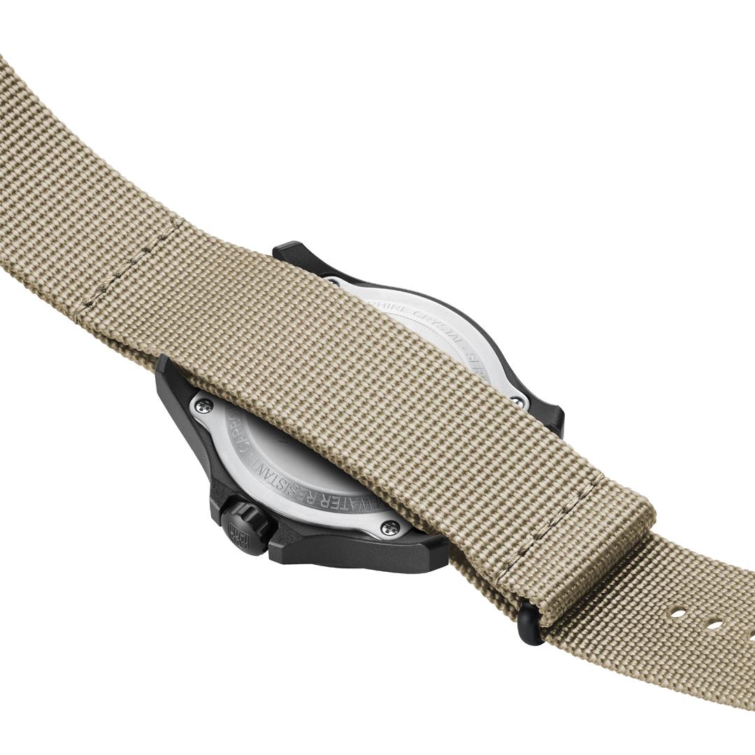 Tan fabric watch strap with metal buckle and black case edge