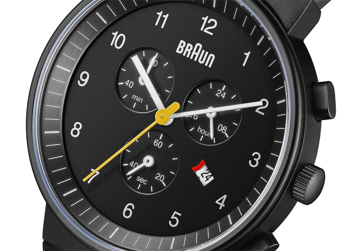 Men's quartz watch close-up with black dial, silver hands, and yellow chronograph accent