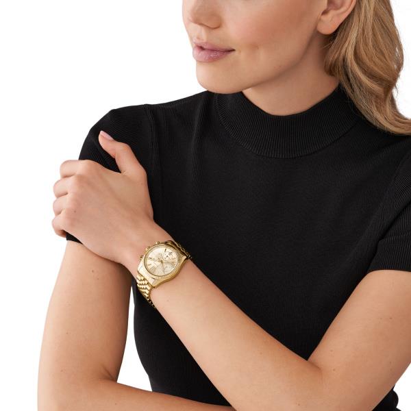 Gold-tone Michael Kors watch on wrist, round gold dial and linked metal bracelet