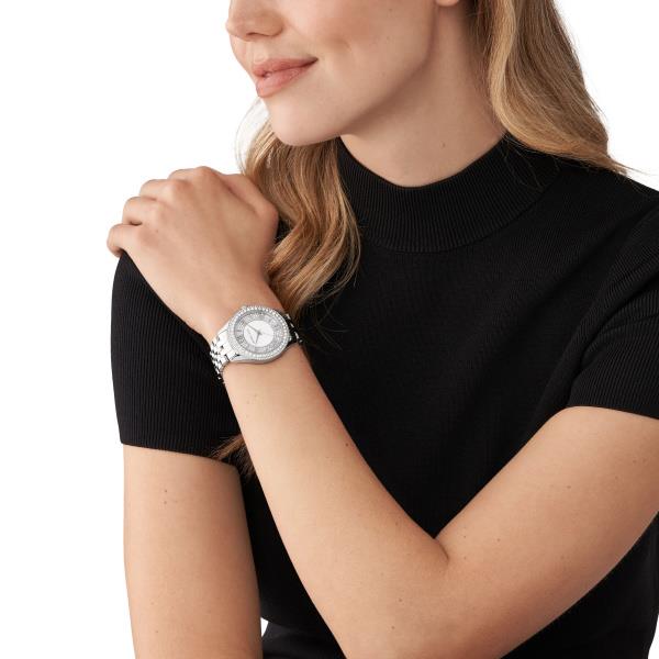 Silver-tone crystal watch worn on wrist with round white dial and metal bracelet.
