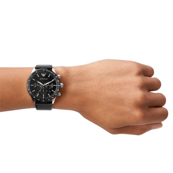Men's chronograph watch on wrist with black dial and black leather strap